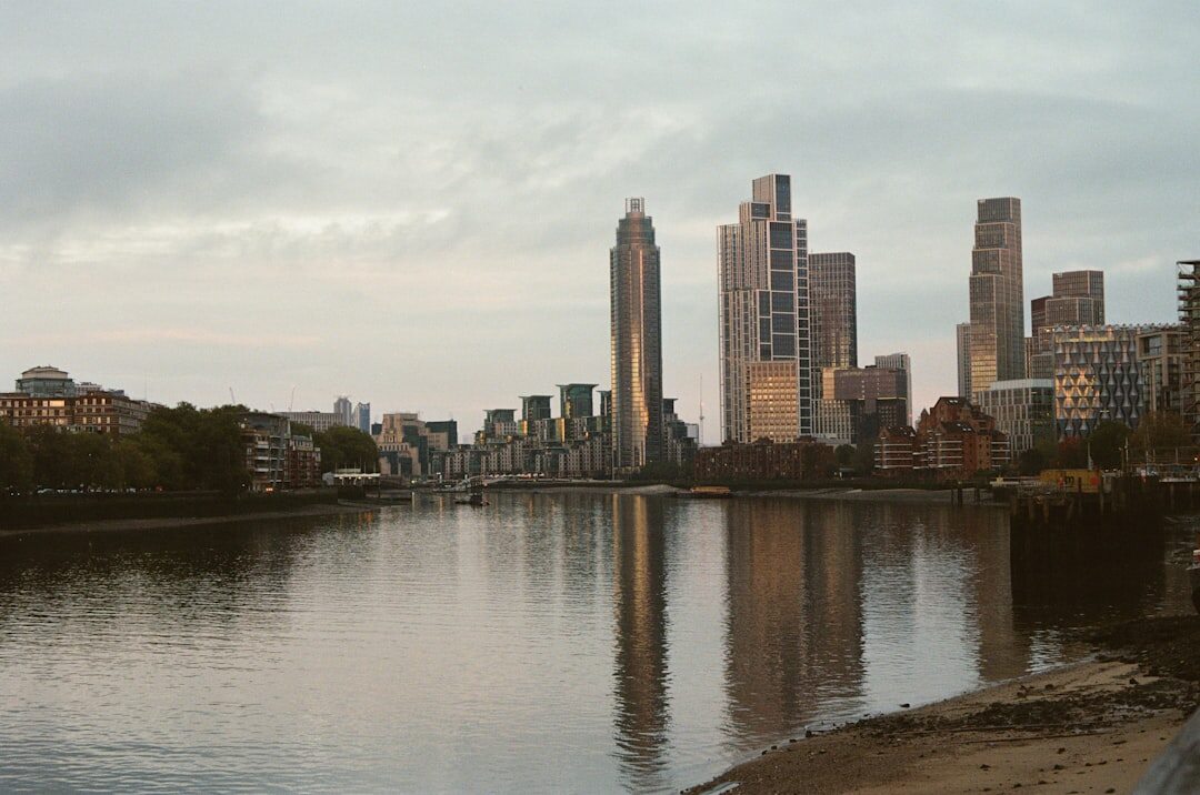 City skyline along a wide river at dusk